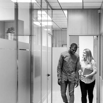 Man and woman walking in office